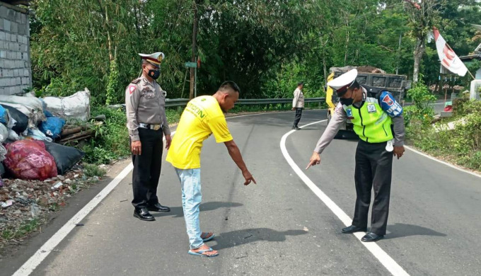 KUMPULKAN BUKTI: Anggota Unit Laka Lantas Satlantas Polres Jember melakukan olah TKP di lokasi kecelakaan, tepatnya di Jalan Prambanan, Desa Kertosari, Kecamatan Pakusari, Jember, Rabu (6/4) pagi.