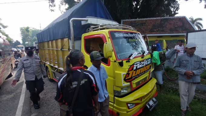 MATI MENDADAK: Personel Polsek Pakusari memeriksa kendaraan yang berhenti di pinggir jalan. Ternyata, sopir truk telah meninggal, diduga akibat serangan jantung.