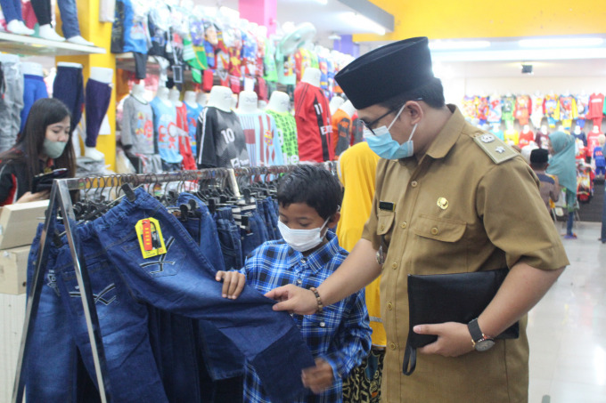 BERBAGI KEBAHAGIAAN: Kepala Desa Sidomulyo, Kecamatan Silo, Jember, Kamiludin ikut memilihkan secara langsung baju untuk anak yatim ketika berbelanja di Toko Jadi Fashion, Jember.