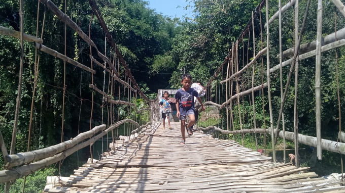 NADI WARGA: Anak kecil sedang bermain melintasi jembatan gantung yang menghubungkan Desa Paguan, Kecamatan Taman Krocok, dengan Desa Traktakan, Kecamatan Wonosari.