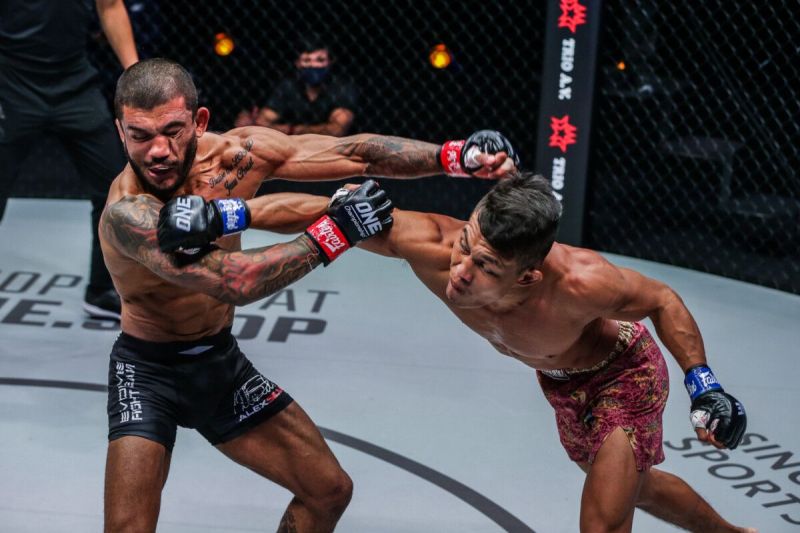 Petarung Indonesia Adrian Mattheis (kanan) melakukan pukulan pada petarung Brazil Alex Silva (kiri) pada laga ONE Championship di Singapore Indoor Stadium, Singapura, 11 Maret 2022.