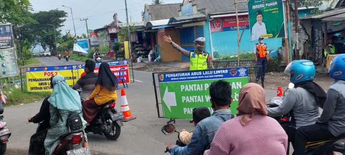 SIAGA: Anggota Polantas Polres Jember mengatur arus lalu lintas ke arah Watu Ulo, Ambulu.