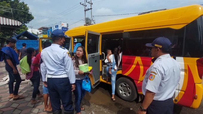GANTI KENDARAAN: Petugas Dishub Jember mengarahkan wisatawan agar menggunakan armada gratis yang disiapkan oleh pemerintah daerah.