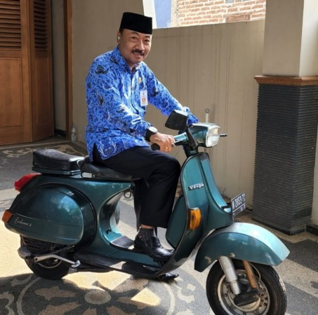 Sapto Djatmiko terlihat gagah dan bangga saat mengendarai Vespa hendak berangkat bekerja.