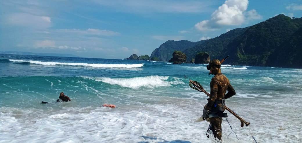 TOMBAK IKAN: Berburu ikan dengan tombak dilakukan warga Wuluhan di Pantai Papuma.