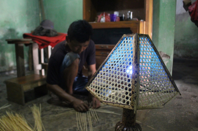 KREATIF: Fauzi Rizal saat menganyam bambu di rumahnya, Desa Glagahwero, Kalisat.