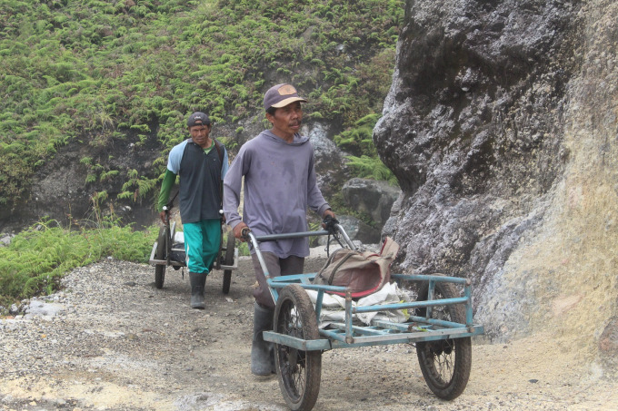KERJA KERAS: Salah satu pengangkut batu belerang ketika mendaki Kawah Ijen. Selain mengangkut belerang, biasanya mereka juga menyediakan jasa ojek troli.