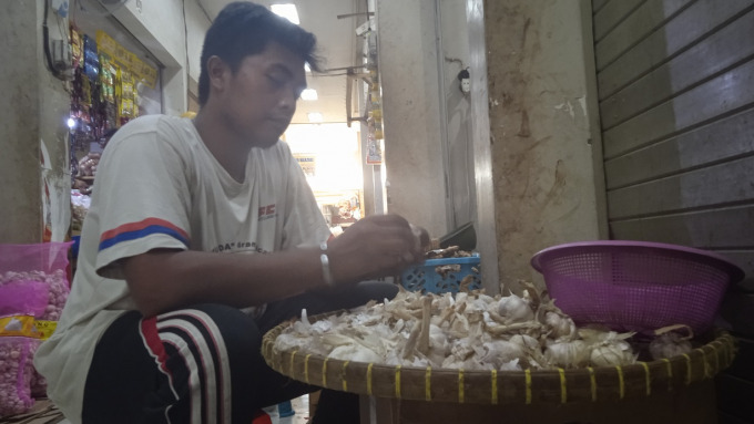 REMPAH IMPOR: Pedagang saat membersihkan bawang putih yang diimpor dari Tiongkok di Pasar Induk Bondowoso. 