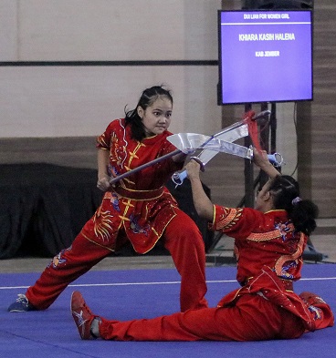 TOTALITAS: Atlet wushu taolu Jember Khiara Kasih Halena dan Sybil Ramadhani yang bermain di beregu putri jurus duilian berhasil meraih medali emas di pertandingan terakhir cabor wushu Porprov Jatim, kemarin (27/8), di Gedung Serbaguna, Kaliwates