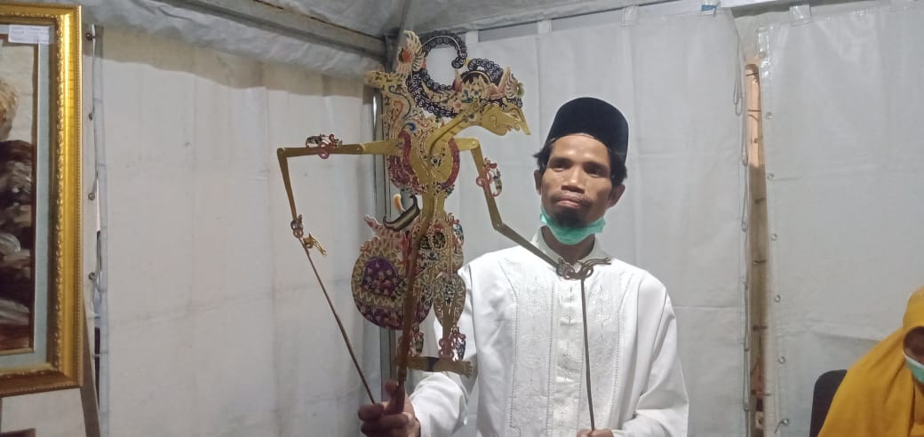 MEMAINKAN: Lasiono, pembuat wayang dari karet talang air asal Umbulsari, saat memainkan wayang gatot kaca.