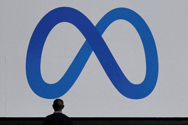 Caption Foto :  FILE PHOTO: A man stands in front of a sign of Meta at its headquarters in Menlo Park, California, U.S. October 28, 2021. REUTERS/Carlos Barria