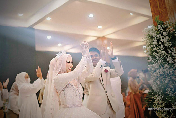 Caption: Mempelai pengantin saat pesta pernikahan.di kebun atau out door, kini menjadi tren pesta pernikahan.
