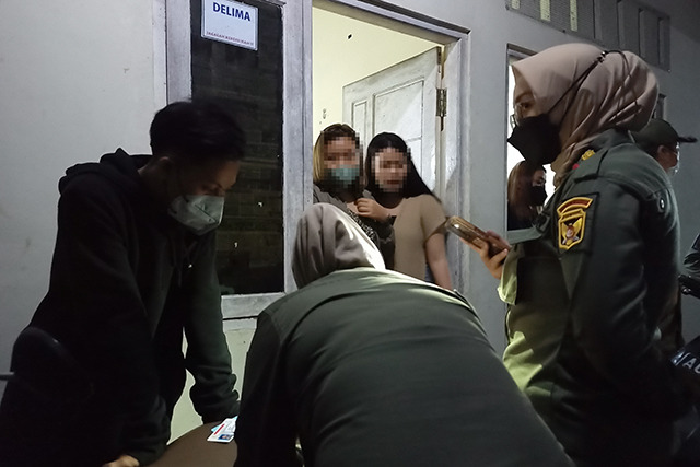 Caption: Anggota Satpol PP Kota Kediri memeriksa identitas para penghuni kamar di salah satu rumah kos yang telah dialihsewakan ke tangan ketiga. (Habibah A. Muktiara/JPRK)