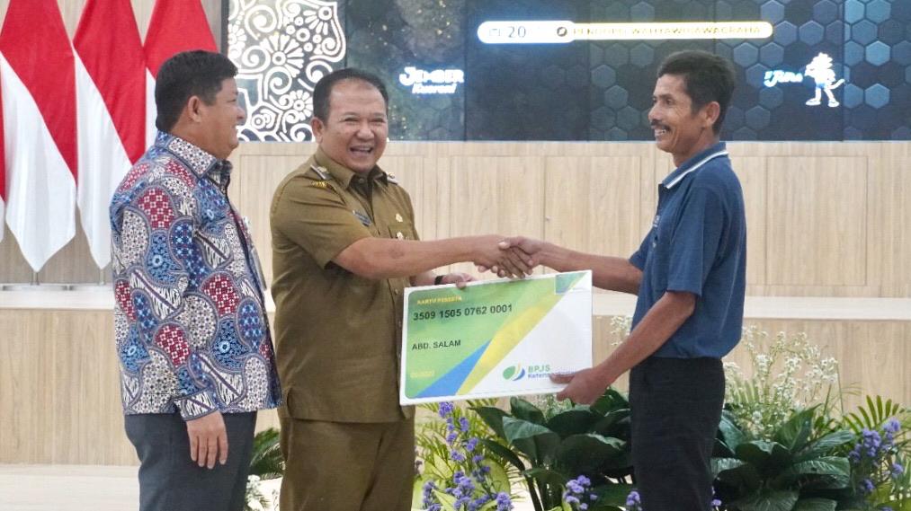 PEDULI: Zainudin, Direktur Kepesertaan BPJAMSOSTEK (Kiri), bersama Bupati Jember Hendy Siswanto saat menyerahkan secara simbolis kartu perlindungan jaminan sosial ketenagakerjaan di Pendapa Wahyawibawagraha, kemarin (20/6).