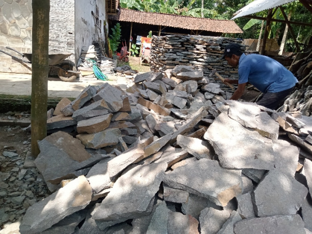 PENUHI PERMINTAAN: Seorang pekerja sedang memotong batu alam di Desa Sumberkalong, Kalisat, kemarin (17/7).