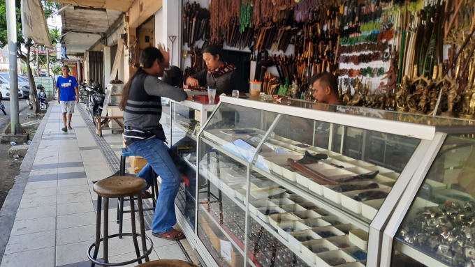 LAYANI PENGUNJUNG: Saputro, salah satu pedagang batu akik, sedang melayani pengunjung. Kini penjualan batu akik menurun drastis.