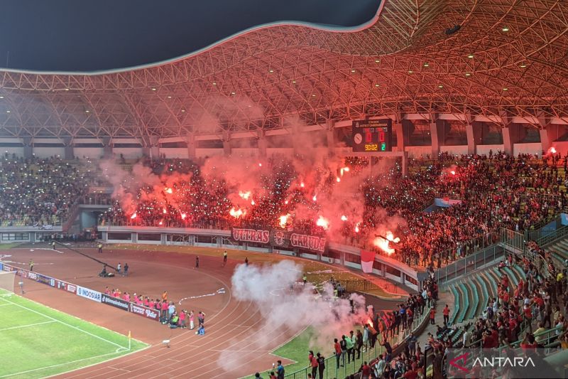 Nyala suar (flare) berwarna merah terlihat di tribun suporter Indonesia pada menit-menit akhir laga Grup A Piala AFF U-19 2022 timnas U-19 Indonesia kontra Vietnam di Stadion Patriot Candrabhaga, Bekasi, Sabtu (2/7). Pertandingan itu sendiri berakhir deng