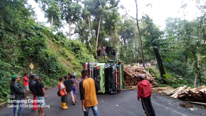 HAMBAT JALAN: Truk pengangkut sengon yang terguling di jalur Gumitir, Minggu (3/7) sore.