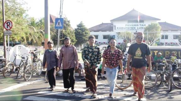 PAMER: Beberapa orang tengah berjalan melintasi area zebra cross Pemkab Lumajang dengan menunjukkan pakaian unik mereka.