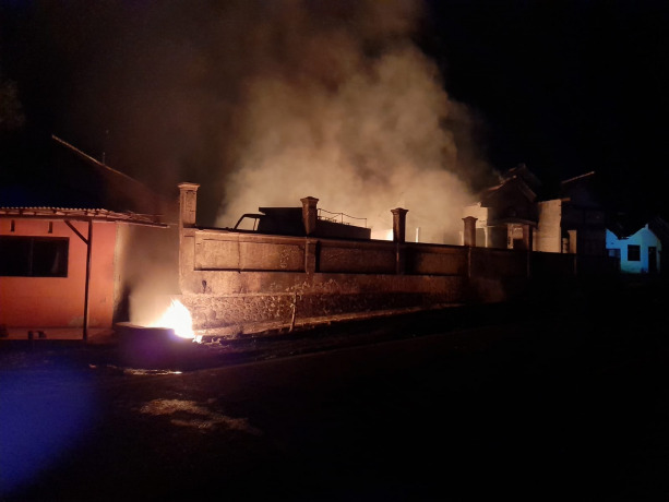 MEMBARA: Kobaran api melalap sebuah rumah yang diduga menjadi tempat penyimpanan solar. Hingga Senin (25/7) malam, petugas masih berusaha memadamkan api.