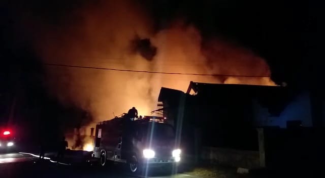 MEMBARA: Sejumlah petugas ketika berupaya memadamkan api. Bangunan itu diduga menjadi tempat penyimpanan solar.