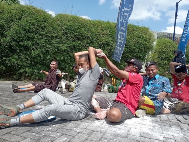 FOKUS: Permainan tepung estafet dilakukan karyawan Radar Jember, kemarin.