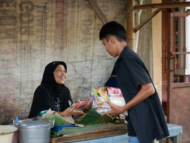 PEDULI SESAMA: Salah satu siswa SMP Al Ikhlash Lumajang saat membagikan paket sembako kepada warga sekitar sekolah, Selasa lalu (16/8). Sebanyak sepuluh ribu sembako dibagikan.