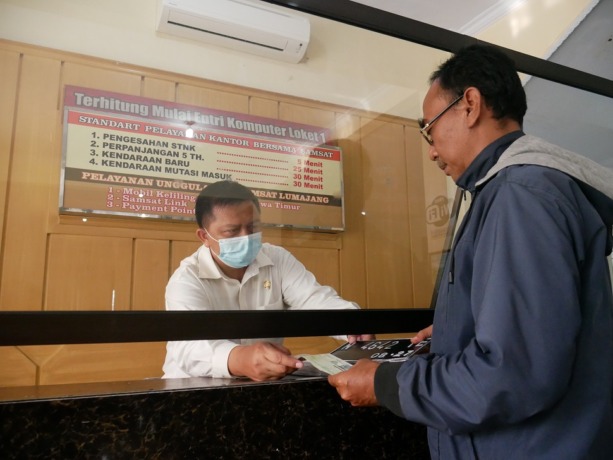 LEBIH RINGAN: Salah satu warga mengurus pemutihan pajak di Kantor Samsat Lumajang, kemarin. Seluruh jenis kendaraan bermotor mendapatkan keringanan denda tunggakan pajak.