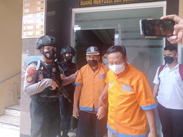 DIGIRING: Kades Barat Supar bersama Sugito, Sekretaris Desa Barat, Kecamatan Padang, saat digiring petugas Polres Lumajang menuju kantor Kejaksaan Negeri Lumajang, Senin (29/08) kemarin.