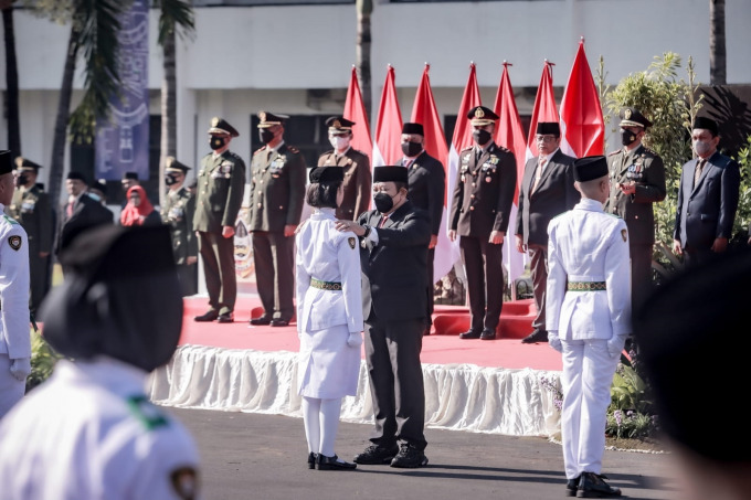 MENGUKUHKAN: Bupati Jember Hendy Siswanto kukuhkan puluhan Paskibraka Jember yang akan bertugas pada upacara peringatan HUT RI ke 77, kemarin pagi (15/8) di depan Pemkab Jember. Anggota Paskibra Jember saat berjalan menuju lokasi pengukuhan.