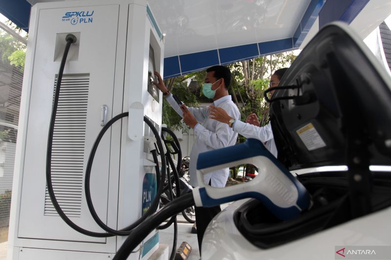 Pengguna mobil listrik mengisi daya di stasiun pengisian kendaraan listrik umum (SPKLU) di Padang, Selasa (26/7/2022).