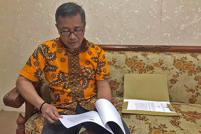 Caption:Adam Muharto,.Kepala BKPSDM Nganjuk membaca peraturan tentang pemberhentian sementara Dupriono dan kawan-kawan kemarin, karena mereka itu kesandung kasus korupsi  (Foto: Andhika Attar)