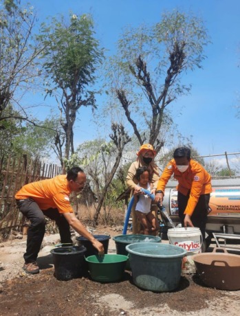 ALIRKAN AIR: Sejumlah masyarakat ketika menyiapkan wadah untuk menerima dropping air bersih dari BPBD Bondowoso. Hal itu rutin dilakukan saat musim kemarau.