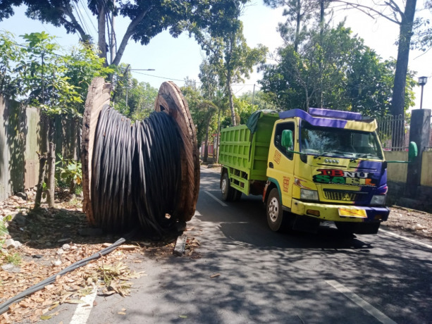 MEMBAHAYAKAN: Kondisi gulungan kabel mangkrak yang menutupi hampir sebagian jalan di Jalan Kutai, Kelurahan Karangrejo, Kecamatan Sumbersari, Jember, kemarin (3/8).
