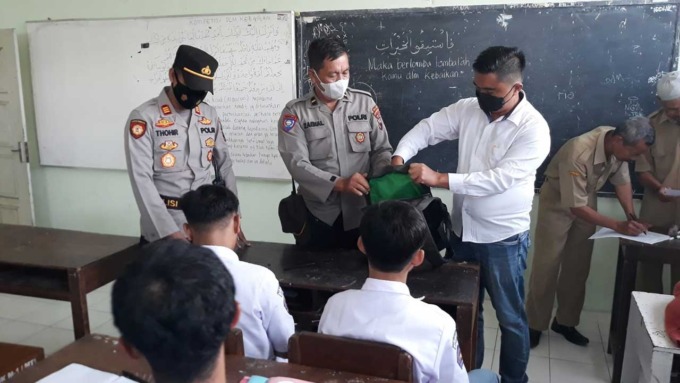 Caption:Beberapa petugas kepolisian dan TNI tampak memeriksa beberapa barang bawaan siswa hingga kendaraan di SMK Muhammadiyah 1 Muntilan ,Kabupaten Magelang, kemarin (1/8).