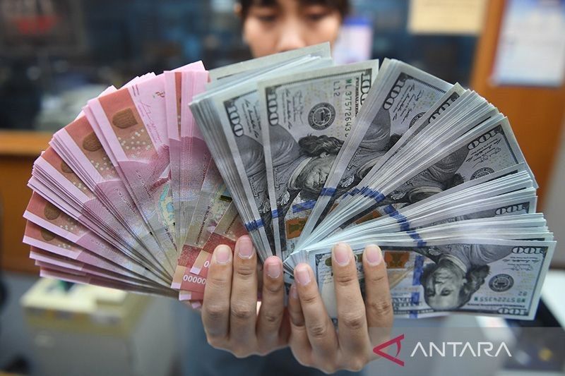 Caption Foto :&nbsp; Ilustrasi - Pekerja menunjukkan uang rupiah dan dolar Amerika Serikat di sebuah tempat penukaran uang di Jakarta.
