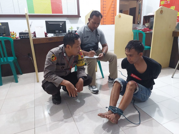 SUDAH DITANGKAP: Irwan Hadi, pelaku pembacokan istrinya sendiri saat diamankan di Polsek Jenggawah, Jumat (12/8).