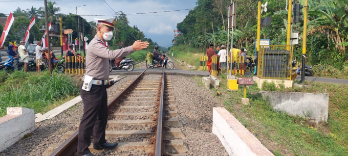 KUMPULKAN BUKTI: Kanit Laka Lantas Satlantas Polres Jember Ipda Edy Purwanto melakukan olah TKP di perlintasan tanpa palang pintu Desa Sumberlesung, Kecamatan Ledokombo, Sabtu (13/8) siang.