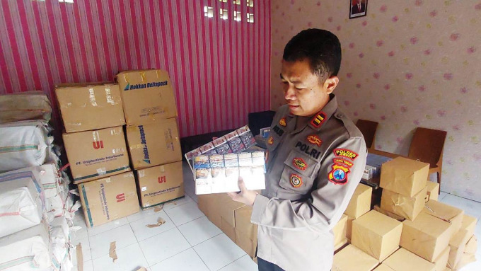TANGKAPAN BESAR: Kapolsek Sukorambi, Jember, Iptu Agus Yudi menunjukkan rokok ilegal yang diamankan dari sebuah truk yang terparkir di wilayah hukumnya.