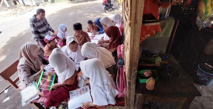 KELAS DARURAT: Sejumlah siswa belajar di sebuah lencak di teras warung milik warga.