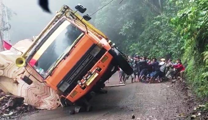 HOLOPIS KUNTUL BARIS: Para sopir truk dan warga membantu proses pengangkatan truk yang terguling di jalur Gumitir, Desa Sidomulyo, Kecamatan Silo, Jember.