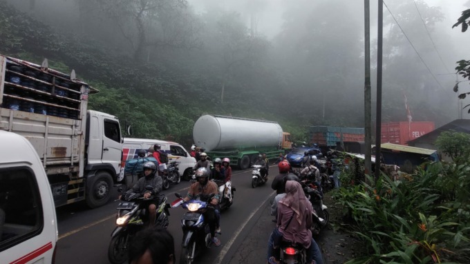 MENGULAR: Antrean kendaraan yang melintas di jalur Gumitir, Desa Sidomulyo, Kecamatan Silo, tersendat akibat truk Fuso terguling di jalur menikung KM 36+800.