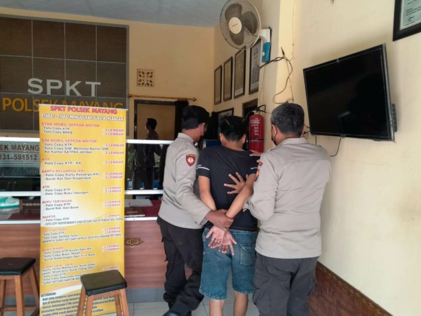 TAK BERKUTIK: Anggota Polsek Mayang membawa Totok Supyanto, seorang buruh bangunan yang tertangkap mengedarkan ribuan pil gedek.