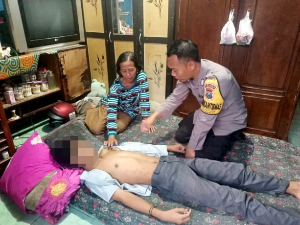 CEK KONDISI: Anggota Polsek Kaliwates mendatangi rumah korban. Pelajar SMPN 12 Jember tersebut pingsan akibat dikeroyok kawanan siswa dari SMP lain.