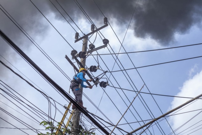 DARURAT: Personel PLN Lumajang menangani jaringan listrik yang terbakar. Sementara ini jaringan diputus untuk penananganan darurat.