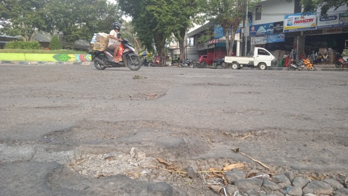 TAK MULUS: Lalu lalang pengendara roda dua di jalan Kota Bondowoso. Sayangnya, masih saja ada jalan kota yang rusak.