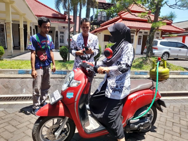 KREATIF: Salah seorang warga ketika melihat dan mencoba langsung motor yang dimodifikasi dengan mengubah sumber bahan bakar BBM menjadi gas.