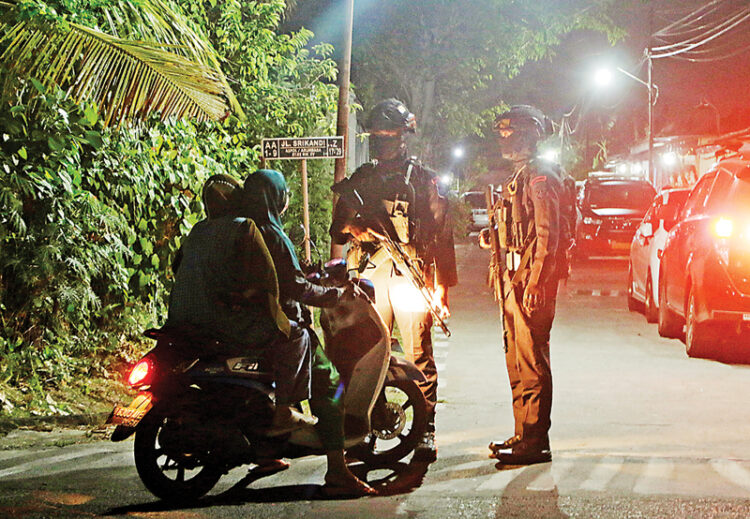 Caption: Anggota Brimob berjaga di akses masuk Asrama Polisi Grogol Indah, Sukoharjo, setelah ledakan di asrama tersebut kemarin (25/9).