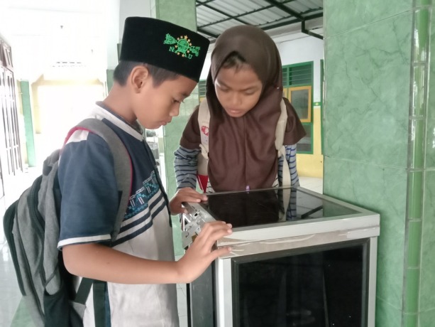 LUDES: Sejumlah siswa melihat kondisi kotak amal yang dirusak dan diraup isinya, kemarin (9/9).