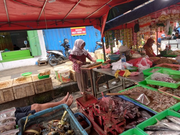 BELUM STABIL: Salah satu pedagang ikan di Pasar Tanjung memotong ikan yang dibeli oleh para pembeli, beberapa waktu lalu.